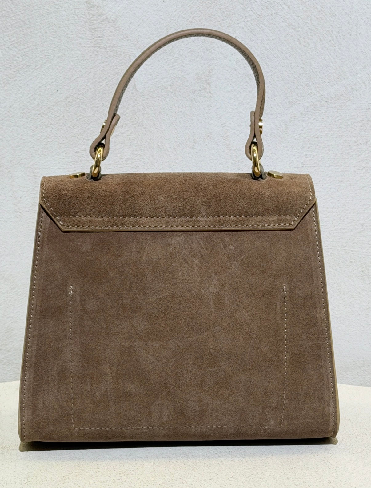 Découvrez l'élégance intemporelle avec ce sac à main d'exception. Confectionné en daim premium, il incarne le raffinement avec ses lignes épurées inspirées des plus grands classiques de la maroquinerie. Sa structure impeccable et sa matière noble en font un accessoire de prestige qui sublimera vos tenues les plus sophistiquées. Un investissement incontournable pour celles qui ne font aucun compromis sur la qualité et le style.