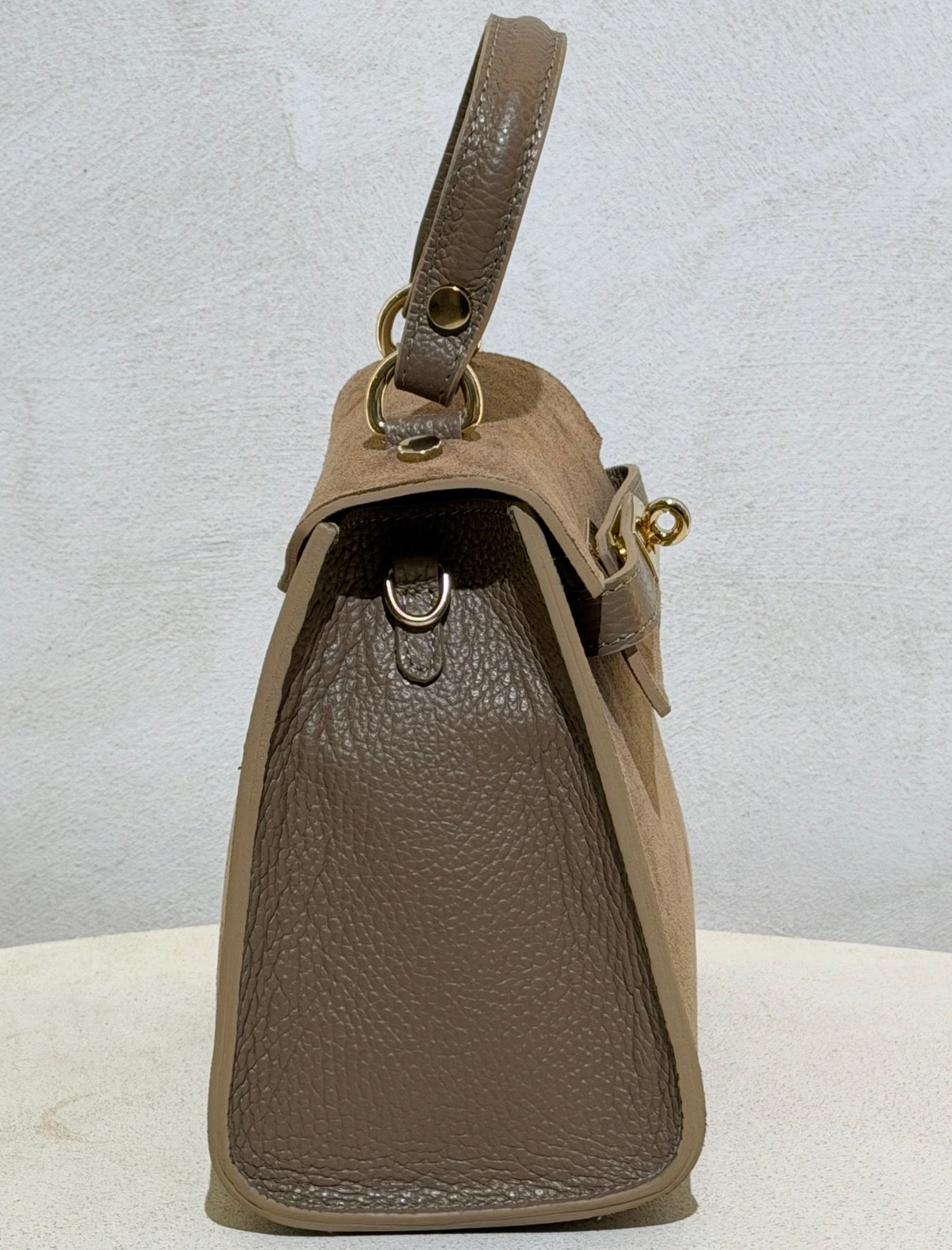 Découvrez l'élégance intemporelle avec ce sac à main d'exception. Confectionné en daim premium, il incarne le raffinement avec ses lignes épurées inspirées des plus grands classiques de la maroquinerie. Sa structure impeccable et sa matière noble en font un accessoire de prestige qui sublimera vos tenues les plus sophistiquées. Un investissement incontournable pour celles qui ne font aucun compromis sur la qualité et le style.