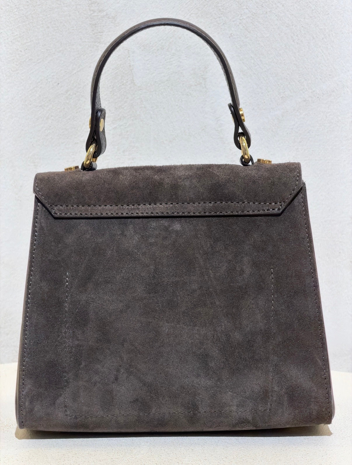 Découvrez l'élégance intemporelle avec ce sac à main d'exception. Confectionné en daim premium, il incarne le raffinement avec ses lignes épurées inspirées des plus grands classiques de la maroquinerie. Sa structure impeccable et sa matière noble en font un accessoire de prestige qui sublimera vos tenues les plus sophistiquées. Un investissement incontournable pour celles qui ne font aucun compromis sur la qualité et le style.