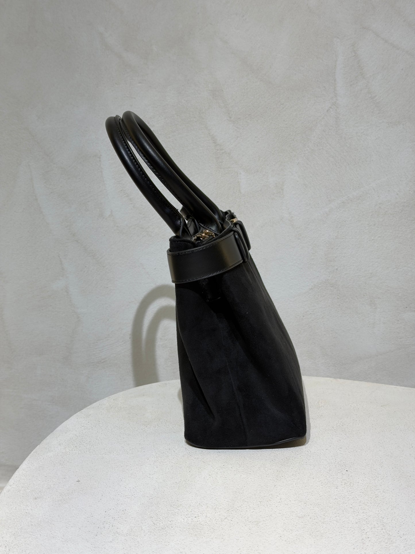 Découvrez le Sac à main Emi, l'accessoire incontournable qui allie élégance et sophistication. Confectionné en daim doux et velouté, ce sac séduira par sa texture raffinée. Rehaussé d'une ceinture en cuir véritable à la taille, il affiche un style classique et intemporel. Les anses en cuir premium garantissent confort et durabilité pour un port quotidien sans compromis. Un sac polyvalent qui transforme chaque tenue en look soigné et chic.

Découvrez l'élégance intemporelle avec ce sac à main en velours soph