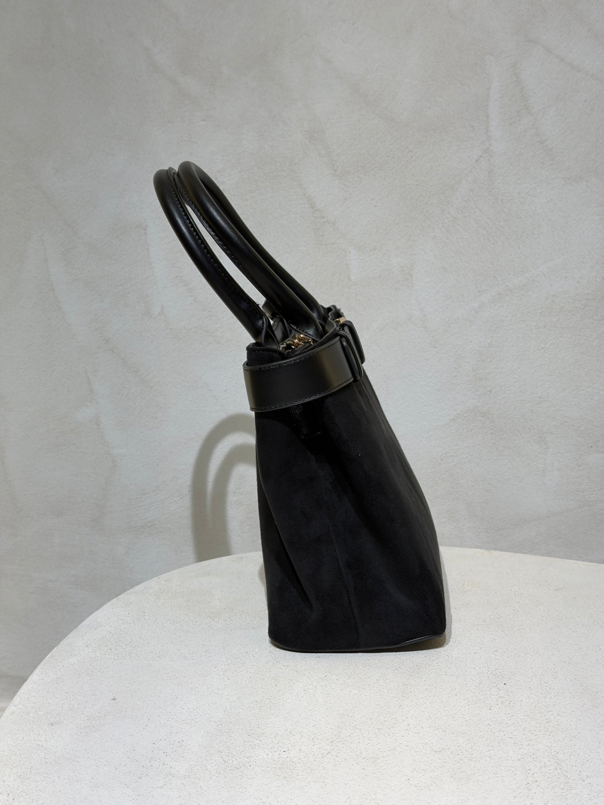 Découvrez le Sac à main Emi, l'accessoire incontournable qui allie élégance et sophistication. Confectionné en daim doux et velouté, ce sac séduira par sa texture raffinée. Rehaussé d'une ceinture en cuir véritable à la taille, il affiche un style classique et intemporel. Les anses en cuir premium garantissent confort et durabilité pour un port quotidien sans compromis. Un sac polyvalent qui transforme chaque tenue en look soigné et chic.

Découvrez l'élégance intemporelle avec ce sac à main en velours soph