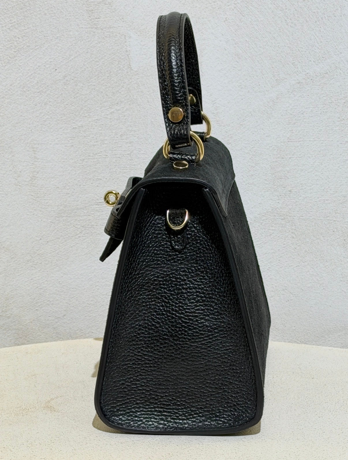 Découvrez l'élégance intemporelle avec ce sac à main d'exception. Confectionné en daim premium, il incarne le raffinement avec ses lignes épurées inspirées des plus grands classiques de la maroquinerie. Sa structure impeccable et sa matière noble en font un accessoire de prestige qui sublimera vos tenues les plus sophistiquées. Un investissement incontournable pour celles qui ne font aucun compromis sur la qualité et le style.