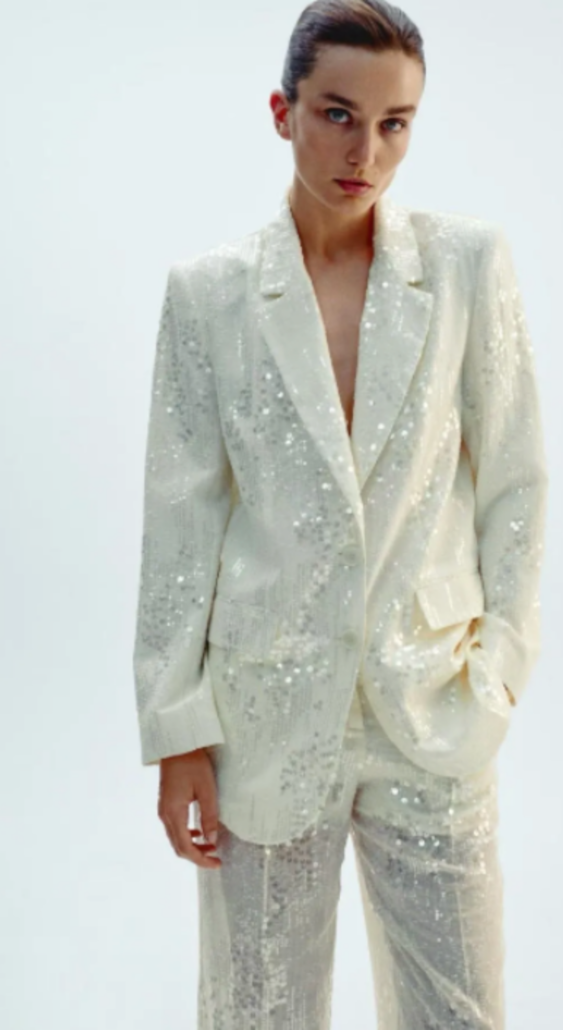 Le blazer Mira en blanc nacré, richement recouvert de paillettes, offre une silhouette élégante sublimée par sa coupe sophistiquée. Doté de deux boutons, il incarne la pièce idéale pour rehausser vos tenues lors d’événements, alliant raffinement et modernité pour une allure impeccable.