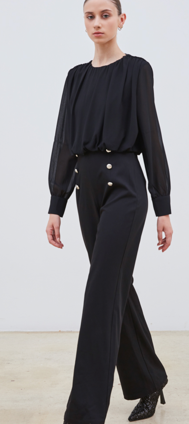La combinaison Elia allie élégance et modernité avec sa coupe bi matière. Son haut semi-transparent apporte une touche de sensualité subtile, tandis que le bas brun met en valeur votre silhouette grâce à ses boutons dorés soigneusement placés sur le devant. Confectionnée dans des matériaux de haute qualité, cette pièce tendance est parfaite pour affirmer votre style avec raffinement lors de vos occasions spéciales.