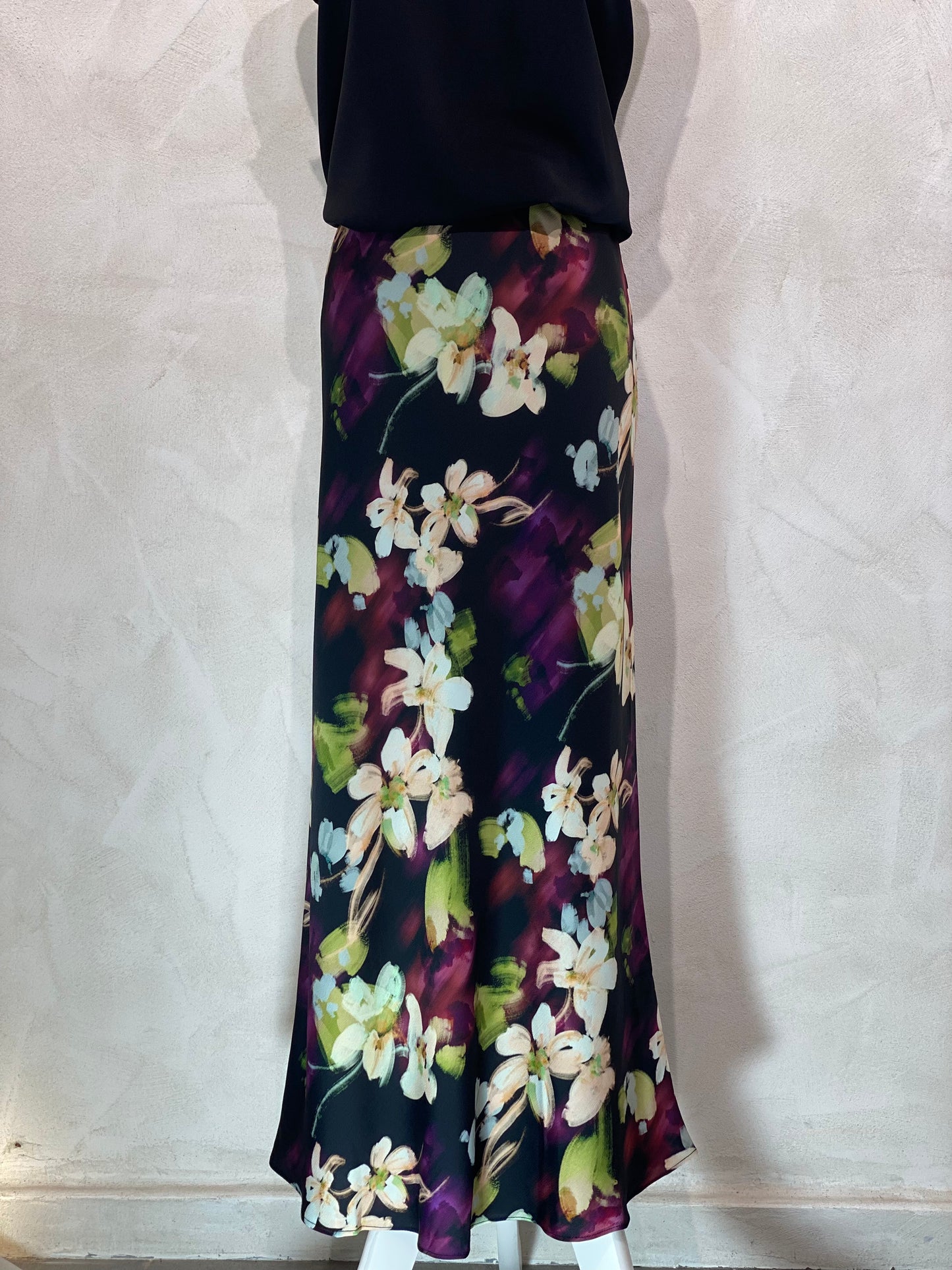 Découvrez la jupe Flora, alliant élégance moderne et raffinement. Son fond noir met en valeur des motifs floraux délicats aux nuances beiges, violettes, vertes et bleu ciel, pour une ambiance chic et contemporaine. Parfaite pour sublimer vos tenues, cette jupe versatile exprime un style sophistiqué avec une touche de fraîcheur colorée.
