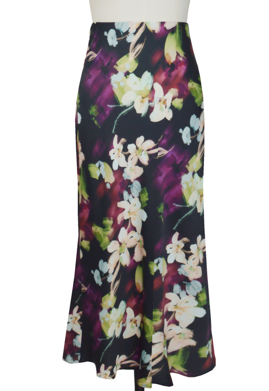 Découvrez la jupe Flora, alliant élégance moderne et raffinement. Son fond noir met en valeur des motifs floraux délicats aux nuances beiges, violettes, vertes et bleu ciel, pour une ambiance chic et contemporaine. Parfaite pour sublimer vos tenues, cette jupe versatile exprime un style sophistiqué avec une touche de fraîcheur colorée.