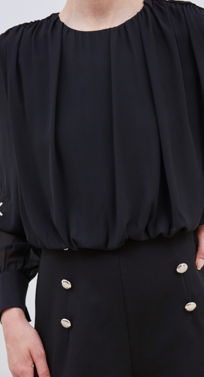 La combinaison Elia allie élégance et modernité avec sa coupe bi matière. Son haut semi-transparent apporte une touche de sensualité subtile, tandis que le bas brun met en valeur votre silhouette grâce à ses boutons dorés soigneusement placés sur le devant. Confectionnée dans des matériaux de haute qualité, cette pièce tendance est parfaite pour affirmer votre style avec raffinement lors de vos occasions spéciales.