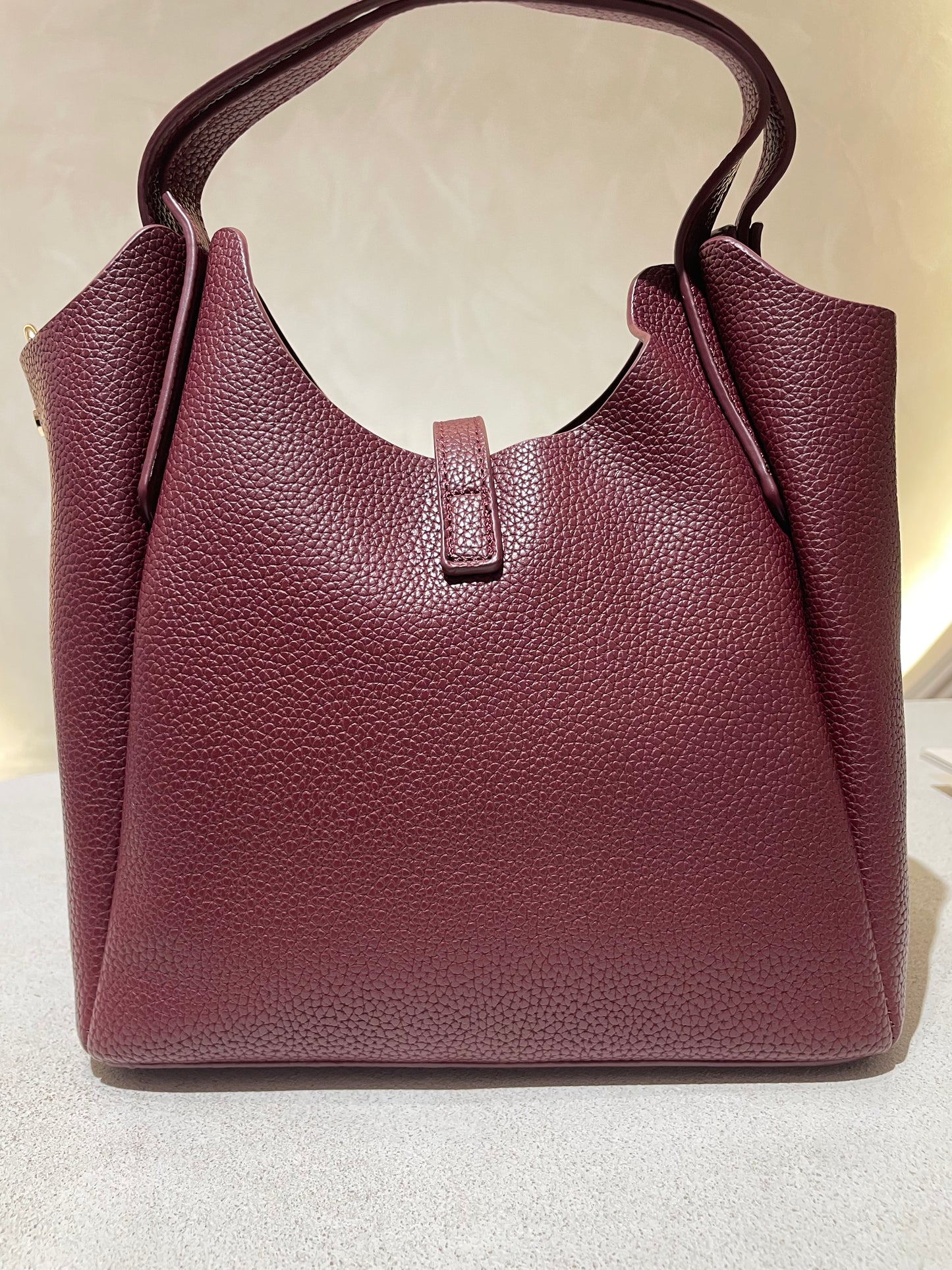 Découvrez le sac à main Hélia, une élégante pièce en simili cuir d'inspiration Hermès qui allie sophistication et raffinement. Disponible en cinq teintes raffinées — bordeaux, taupe, noir, camel et marron — ce sac se distingue par sa silhouette soignée et ses détails minutieux, notamment l’emblématique « H » en acier inoxydable doré. Avec une dimension idéale de 25 x 25 cm et une épaisseur de 14 cm, il offre un équilibre parfait entre style et fonctionnalité. Une bandoulière amovible complète ce modèle pour