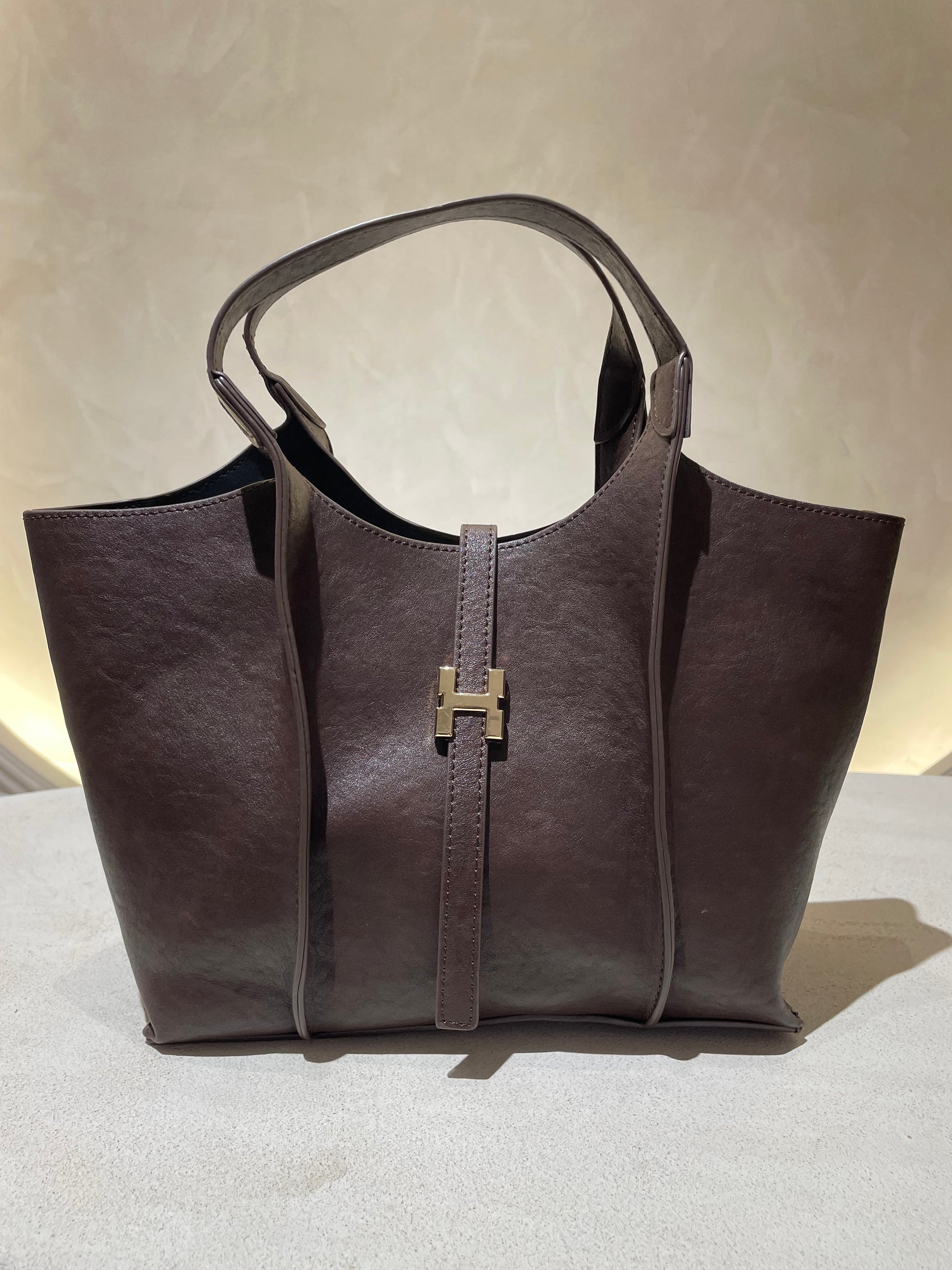Le sac à main Hadra allie élégance et tendance avec son cuir façon Hermès aux teintes noire, marron et camel. Son design raffiné et ses détails minutieux en font un accessoire classe, parfait pour rehausser votre style. Polyvalent, il peut se porter avec ou sans bandoulière, s’adaptant à toutes vos envies. Adoptez une allure chic et moderne grâce à ce sac incontournable de la saison.