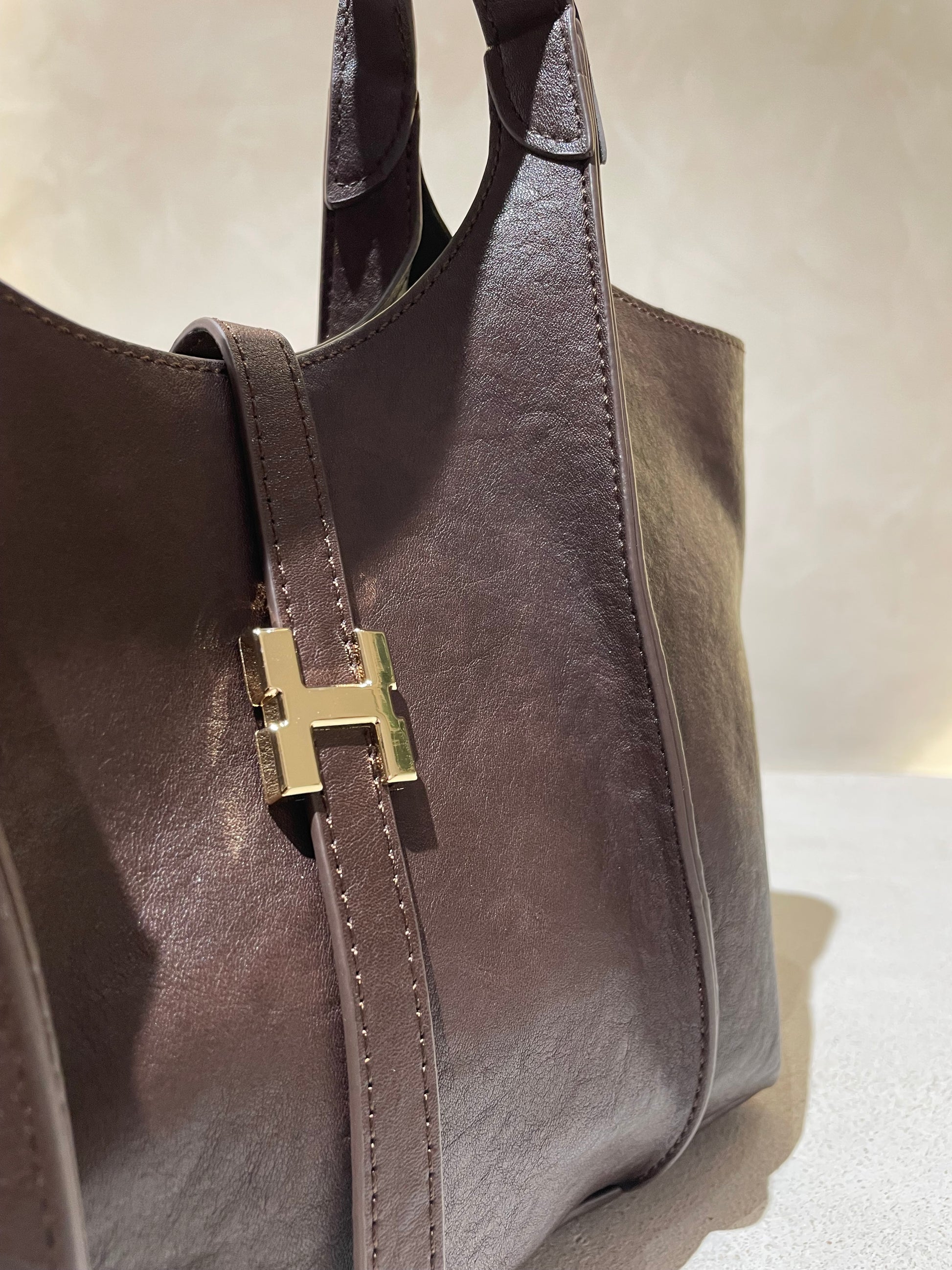 Le sac à main Hadra allie élégance et tendance avec son cuir façon Hermès aux teintes noire, marron et camel. Son design raffiné et ses détails minutieux en font un accessoire classe, parfait pour rehausser votre style. Polyvalent, il peut se porter avec ou sans bandoulière, s’adaptant à toutes vos envies. Adoptez une allure chic et moderne grâce à ce sac incontournable de la saison.