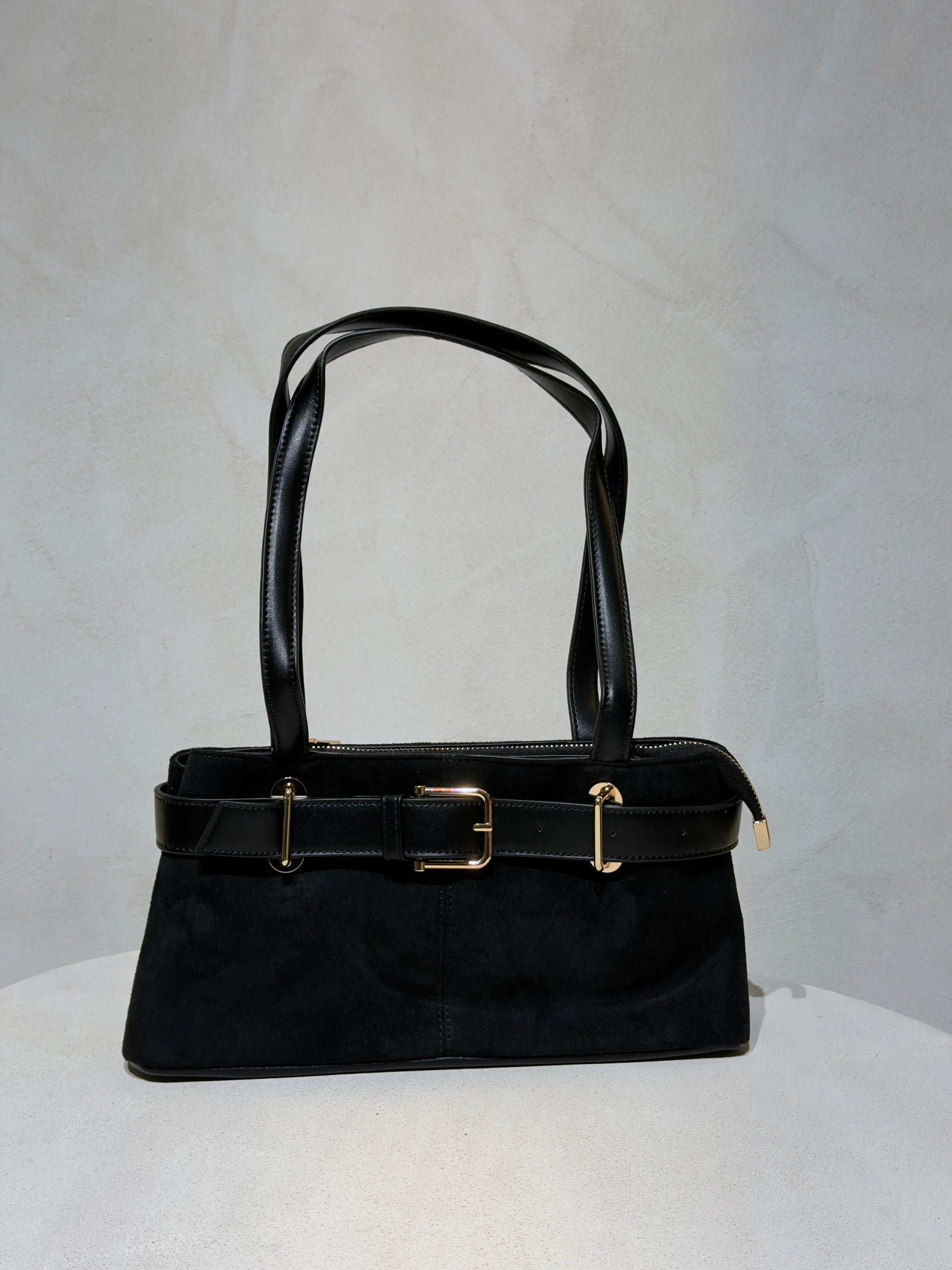 Découvrez le Sac à main Emi, l'accessoire incontournable qui allie élégance et sophistication. Confectionné en daim doux et velouté, ce sac séduira par sa texture raffinée. Rehaussé d'une ceinture en cuir véritable à la taille, il affiche un style classique et intemporel. Les anses en cuir premium garantissent confort et durabilité pour un port quotidien sans compromis. Un sac polyvalent qui transforme chaque tenue en look soigné et chic.

Découvrez l'élégance intemporelle avec ce sac à main en velours soph