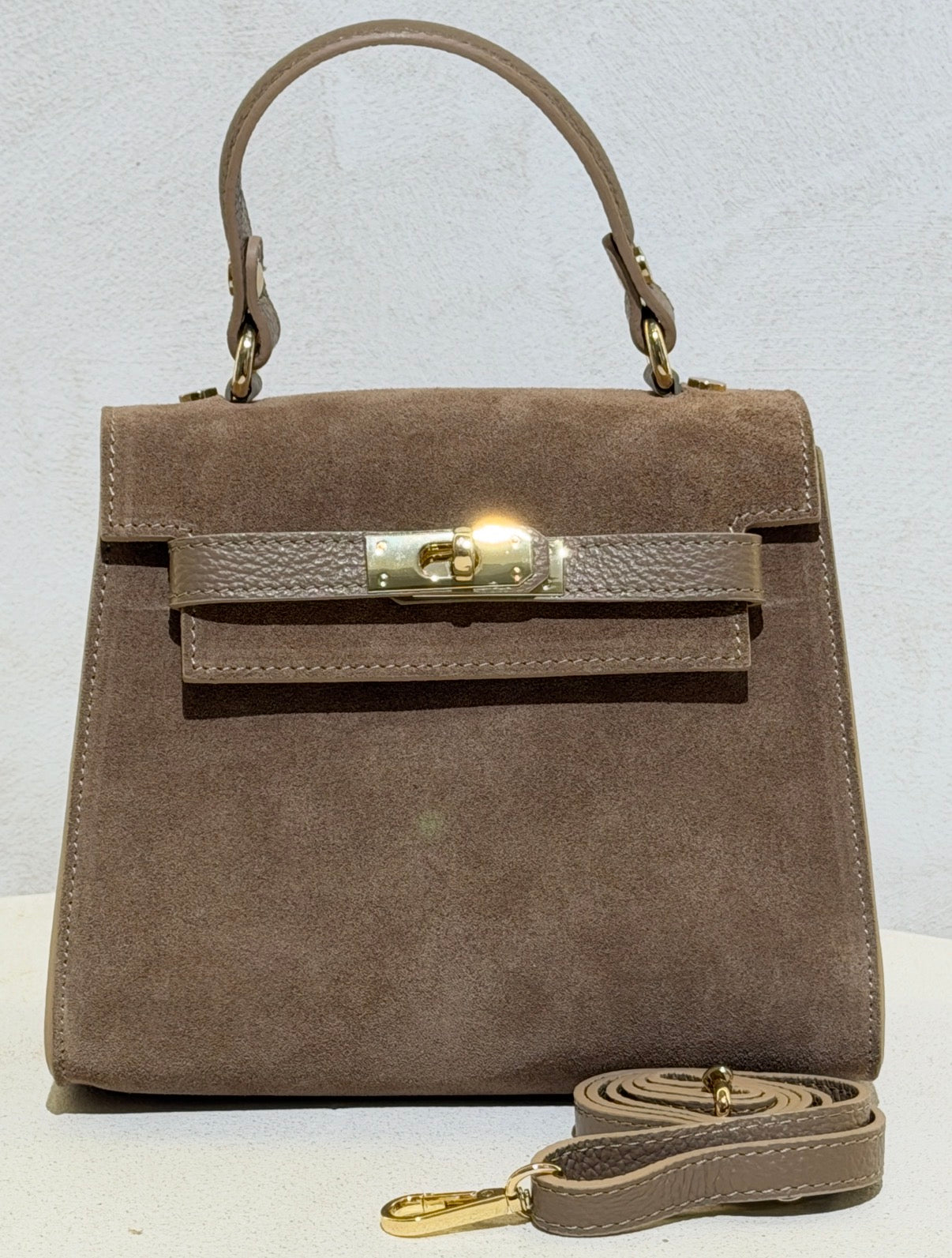 Découvrez l'élégance intemporelle avec ce sac à main d'exception. Confectionné en daim premium, il incarne le raffinement avec ses lignes épurées inspirées des plus grands classiques de la maroquinerie. Sa structure impeccable et sa matière noble en font un accessoire de prestige qui sublimera vos tenues les plus sophistiquées. Un investissement incontournable pour celles qui ne font aucun compromis sur la qualité et le style.