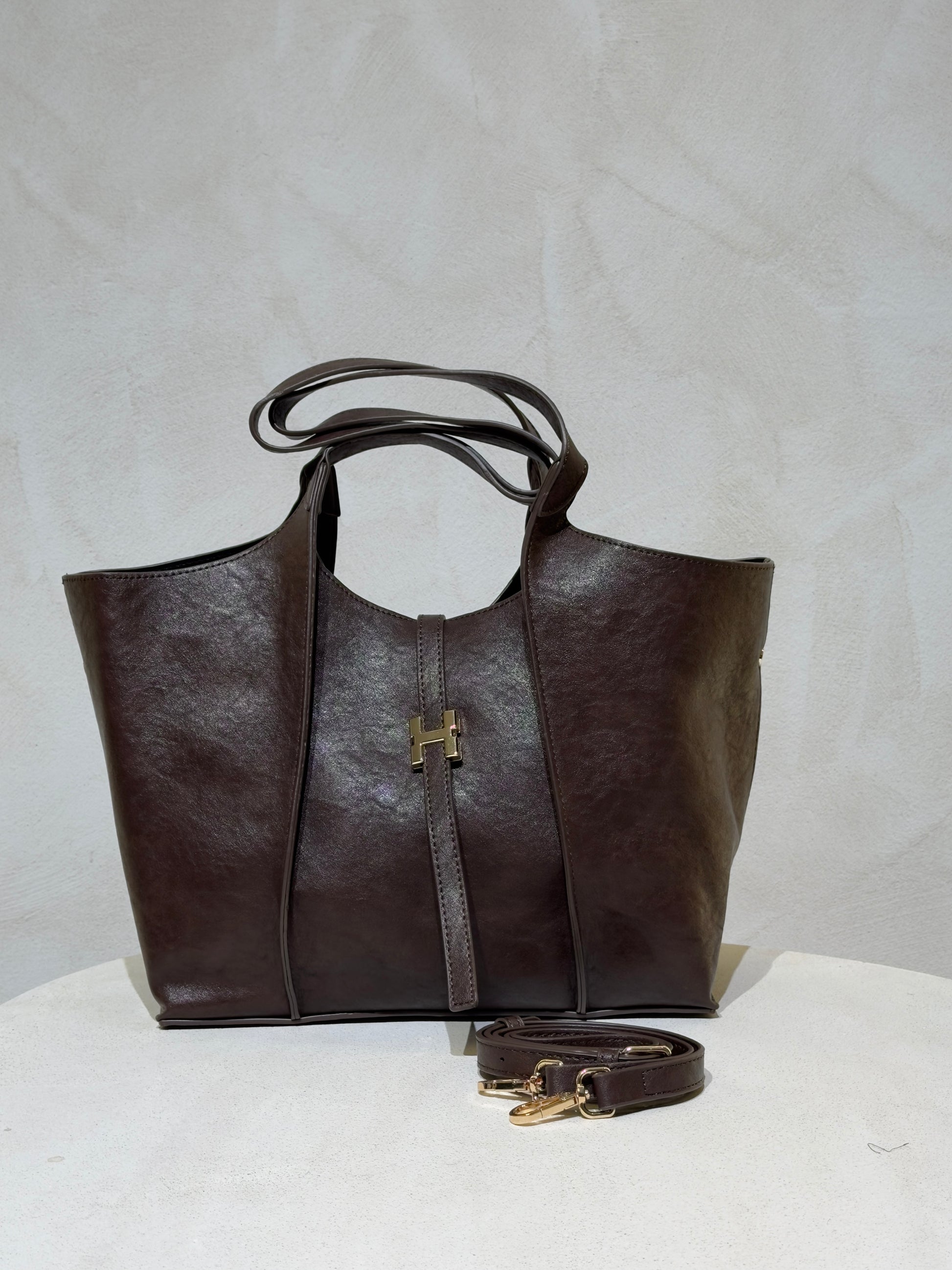 Le sac à main Hadra allie élégance et tendance avec son cuir façon Hermès aux teintes noire, marron et camel. Son design raffiné et ses détails minutieux en font un accessoire classe, parfait pour rehausser votre style. Polyvalent, il peut se porter avec ou sans bandoulière, s’adaptant à toutes vos envies. Adoptez une allure chic et moderne grâce à ce sac incontournable de la saison.