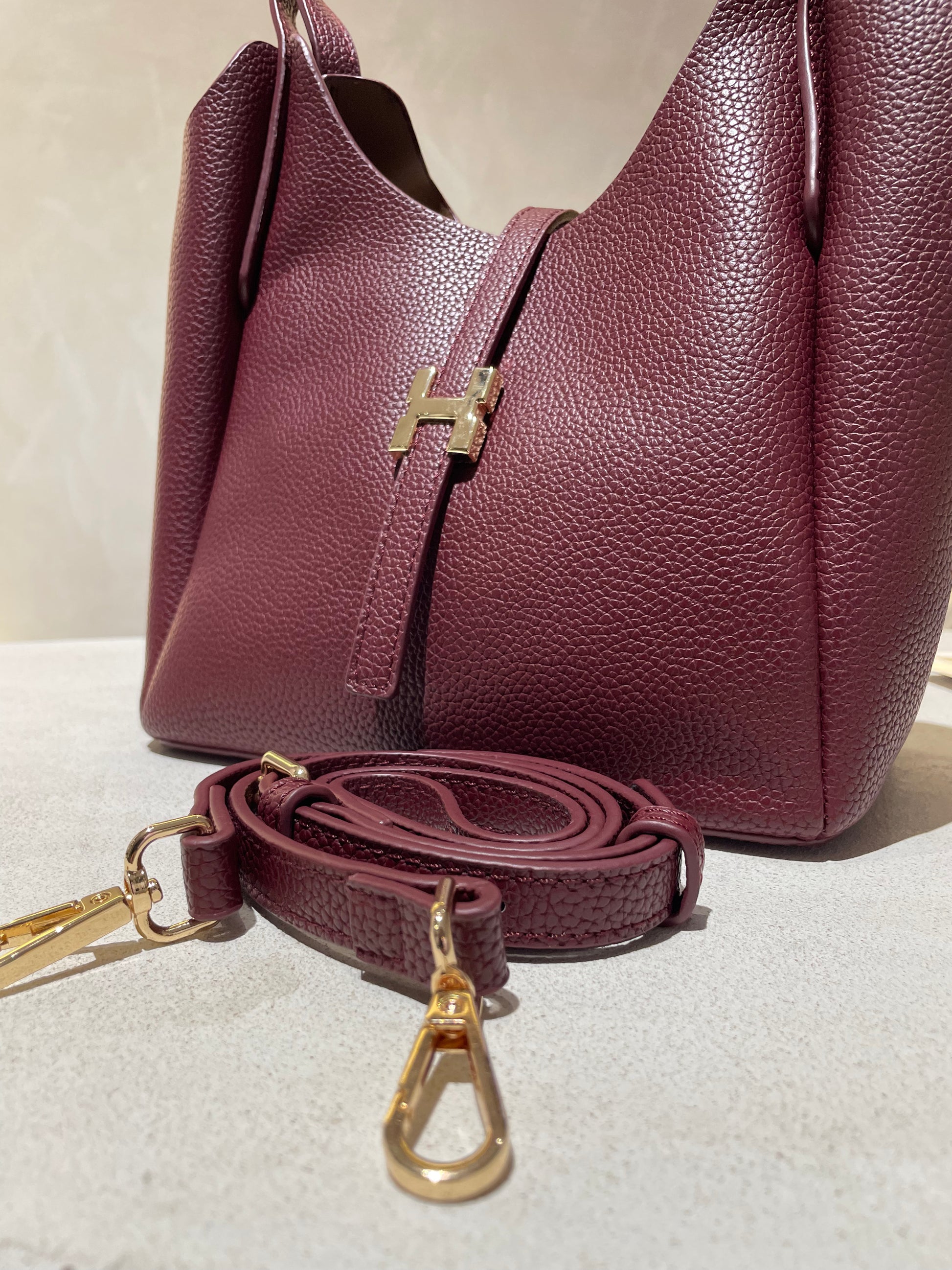 Découvrez le sac à main Hélia, une élégante pièce en simili cuir d'inspiration Hermès qui allie sophistication et raffinement. Disponible en cinq teintes raffinées — bordeaux, taupe, noir, camel et marron — ce sac se distingue par sa silhouette soignée et ses détails minutieux, notamment l’emblématique « H » en acier inoxydable doré. Avec une dimension idéale de 25 x 25 cm et une épaisseur de 14 cm, il offre un équilibre parfait entre style et fonctionnalité. Une bandoulière amovible complète ce modèle pour