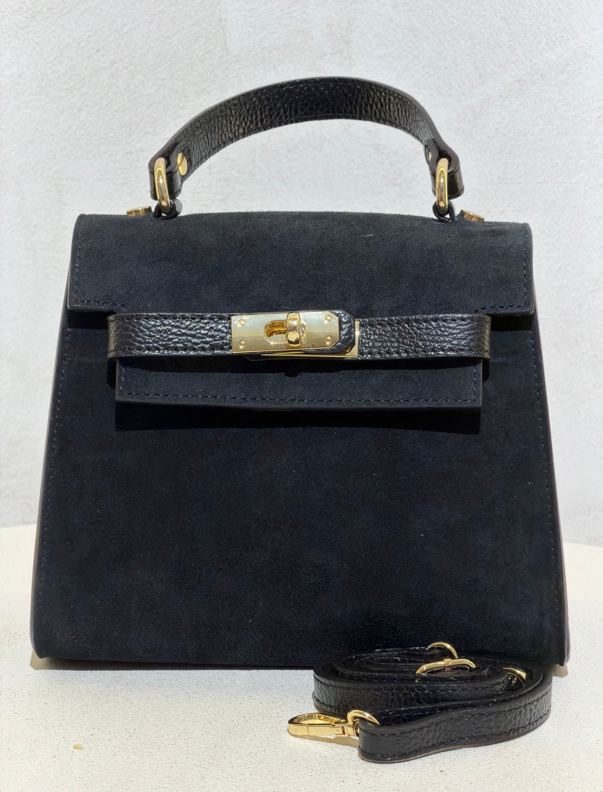 Découvrez l'élégance intemporelle avec ce sac à main d'exception. Confectionné en daim premium, il incarne le raffinement avec ses lignes épurées inspirées des plus grands classiques de la maroquinerie. Sa structure impeccable et sa matière noble en font un accessoire de prestige qui sublimera vos tenues les plus sophistiquées. Un investissement incontournable pour celles qui ne font aucun compromis sur la qualité et le style.