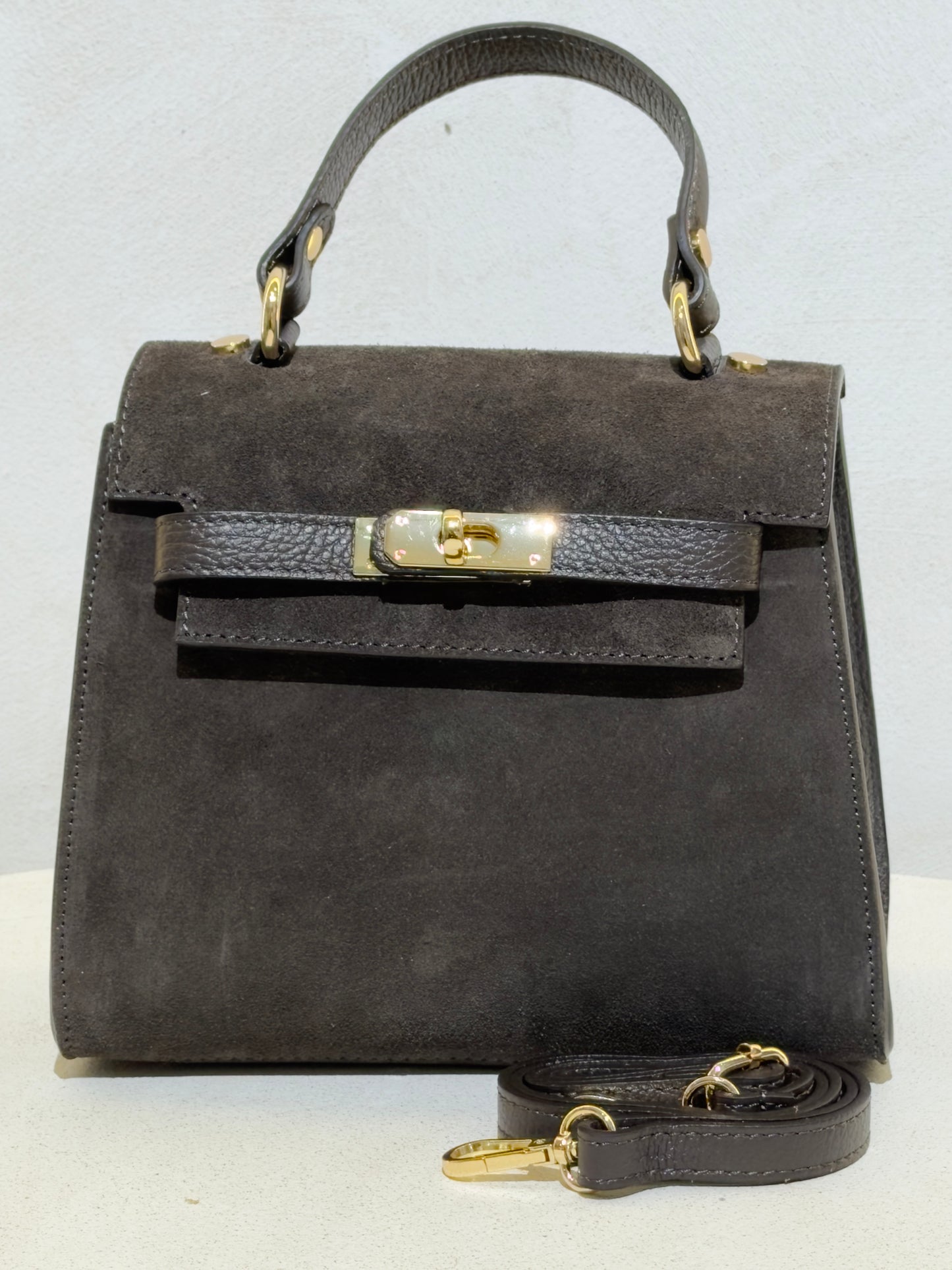 Découvrez l'élégance intemporelle avec ce sac à main d'exception. Confectionné en daim premium, il incarne le raffinement avec ses lignes épurées inspirées des plus grands classiques de la maroquinerie. Sa structure impeccable et sa matière noble en font un accessoire de prestige qui sublimera vos tenues les plus sophistiquées. Un investissement incontournable pour celles qui ne font aucun compromis sur la qualité et le style.