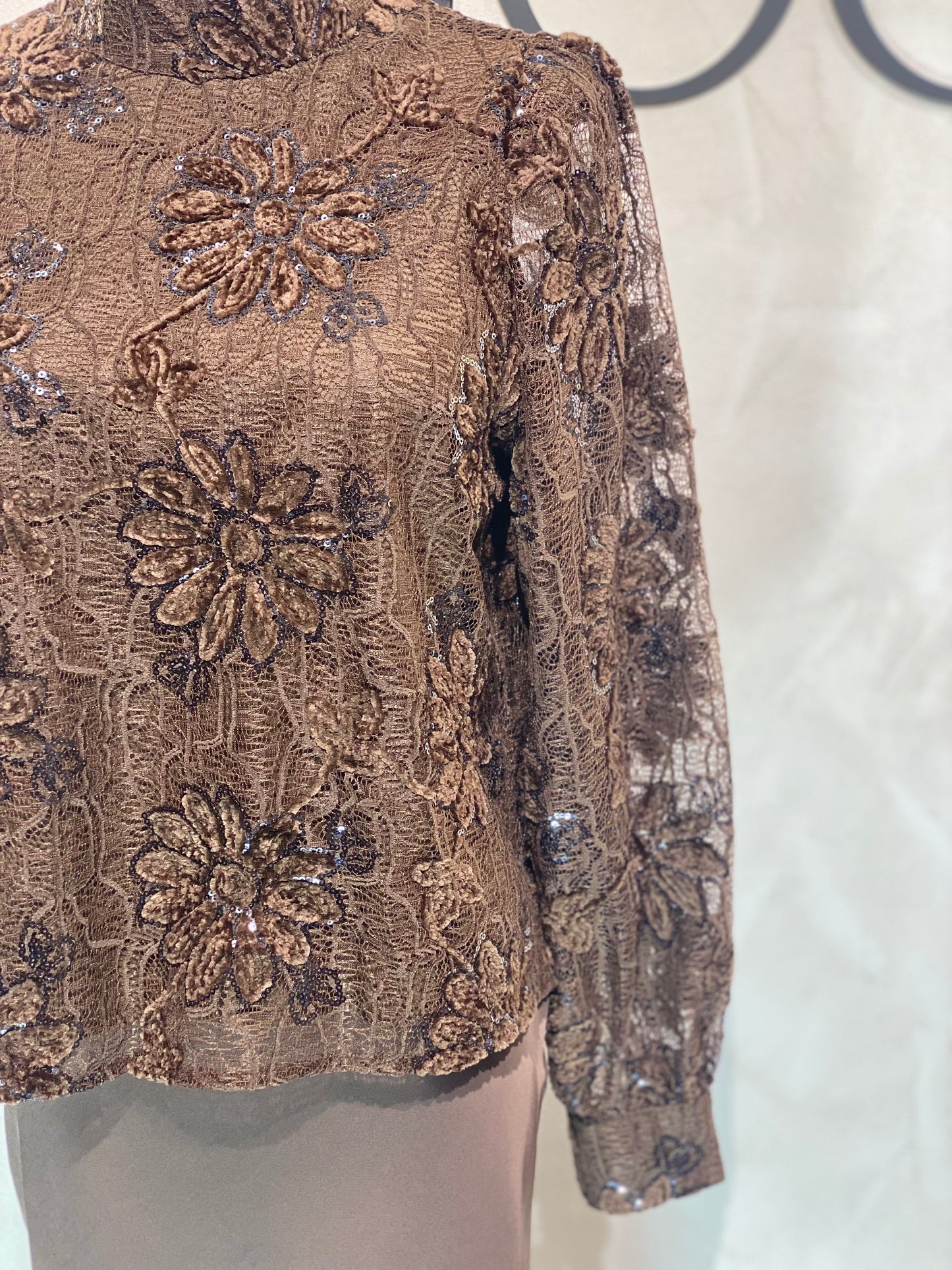 Le Haut Sandra allie élégance et modernité avec son col rond sophistiqué et sa délicate broderie en dentelle blanc nacré. Ses manches transparentes offrent une touche de légèreté, tandis que la finition impeccable garantit un look chic et raffiné. Idéal pour celles qui souhaitent se démarquer avec style et délicatesse.
