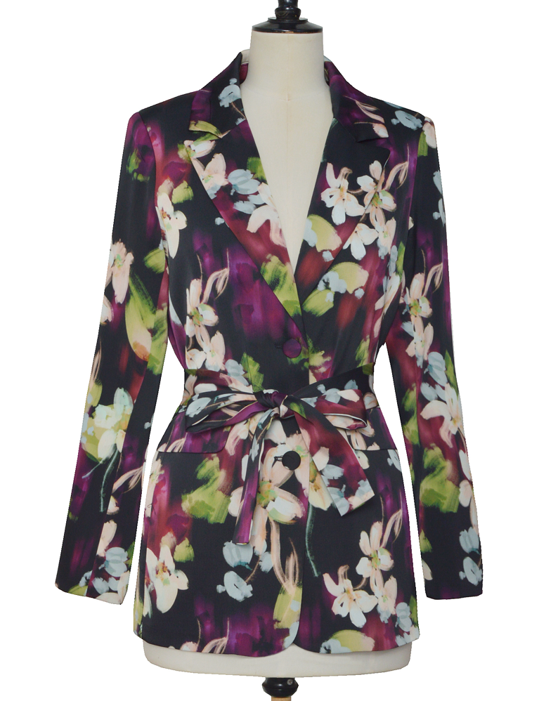 La veste Flora allie élégance et originalité avec ses motifs floraux abstraits aux nuances subtiles de beige, violet, bleu ciel et vert sur un fond noir profond. Sa coupe chic est sublimée par une ceinture et deux boutons délicats, apportant une touche raffinée et structurée. Parfaite pour affirmer un style sophistiqué tout en restant tendance.