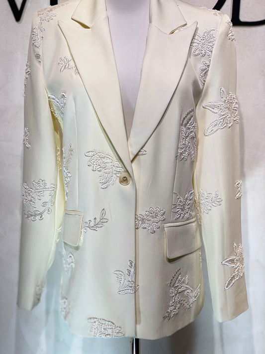 Découvrez la veste perlée Amira, un blazer blanc cassé d'exception orné de perles blanches de haute qualité. Son unique bouton apporte une touche d’élégance raffinée, parfaite pour sublimer vos tenues lors d’événements prestigieux. Cette pièce allie sophistication et style intemporel, garantissant une allure distinguée en toutes circonstances.